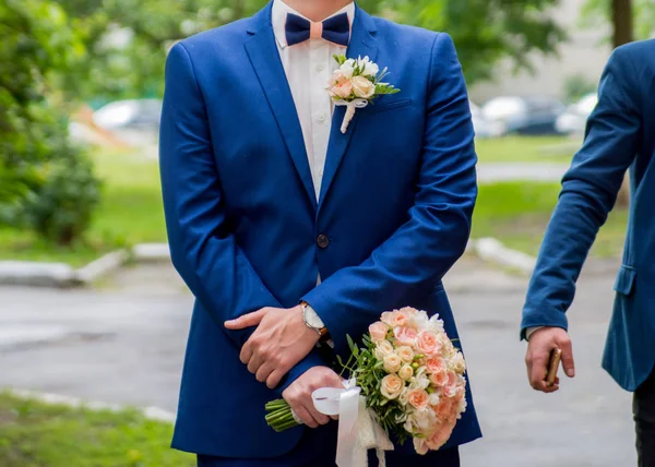 O noivo está segurando um buquê de casamento — Fotografia de Stock