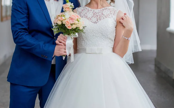 Bruden och brudgummen stå tillsammans med buketten — Stockfoto