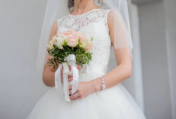 Die Braut hält einen Hochzeitsstrauß — Stockfoto