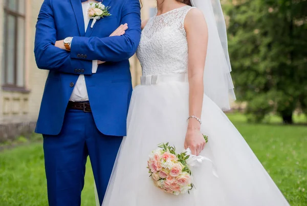 Bruden och brudgummen står tillsammans i parken — Stockfoto