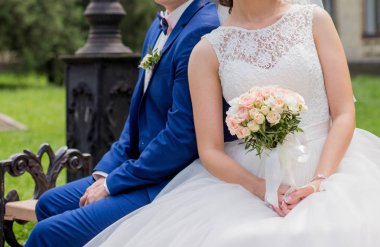 Gelin ve damat parkta bir bankta oturup