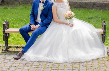 Gelin ve damat parkta bir bankta oturup