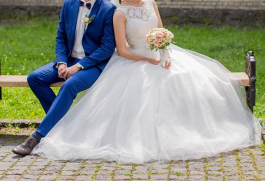 Gelin ve damat parkta bir bankta oturup