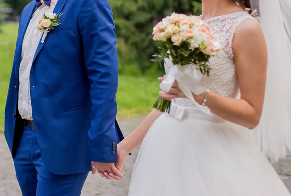 Bruden och brudgummen står tillsammans i parken — Stockfoto