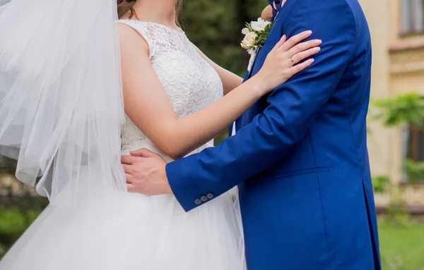 The bride and groom stand together in the park — Stock Photo, Image