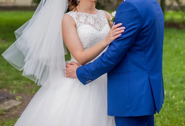 The bride and groom stand together in the park — Stock Photo, Image