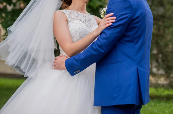 The bride and groom stand together in the park — Stock Photo, Image