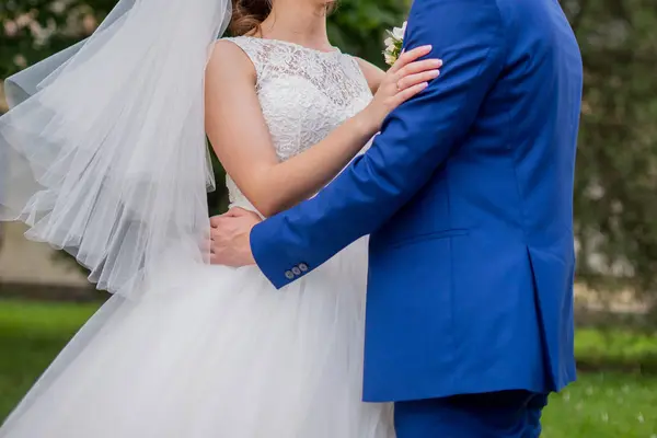 The bride and groom stand together in the park — Stock Photo, Image