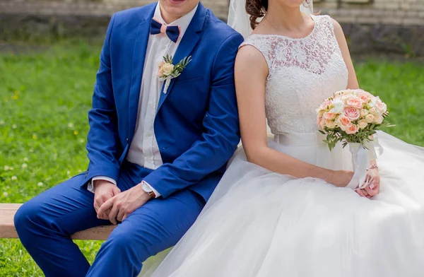 Los novios se sientan en un banco en el parque — Foto de Stock