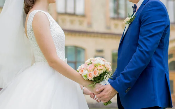 Bruden och brudgummen håller händer i parken — Stockfoto