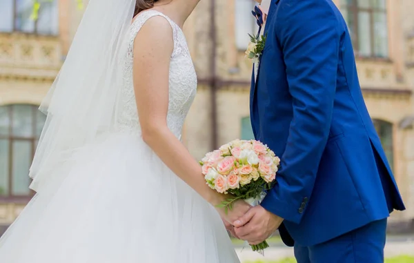 The bride and groom are holding hands in the park — Stock Photo, Image