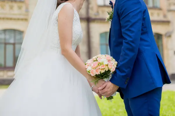 The bride and groom are holding hands in the park — Stock Photo, Image