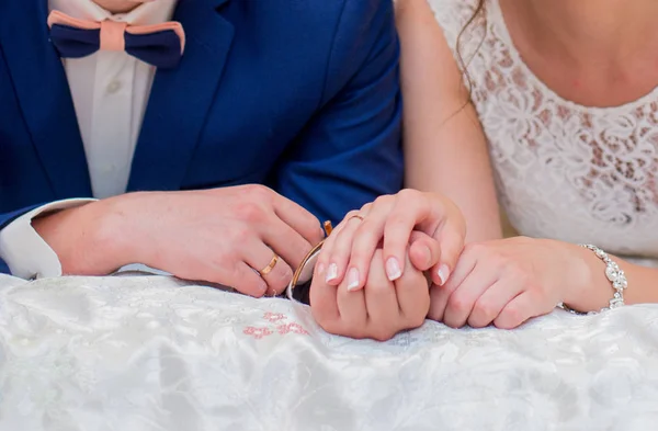 The bride and groom are lying on the bed and are holding hands — Stock Photo, Image