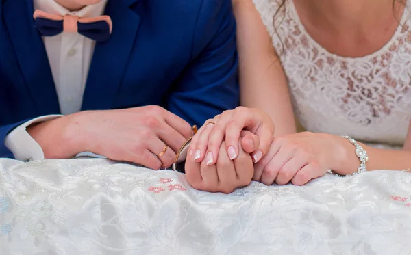 A noiva e o noivo estão deitados na cama e de mãos dadas — Fotografia de Stock