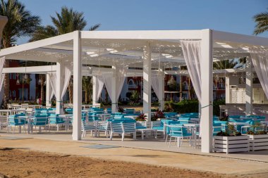 Mavi masa ve sandalyeler güneş ışığı altında açık havada kafe