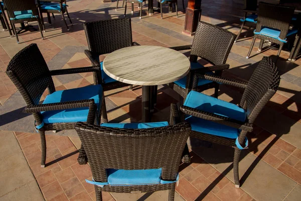 outdoors cafe with blue chairs and tables in sunlight