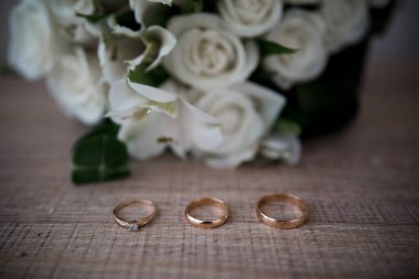 Tahta bir masada altın alyanslar