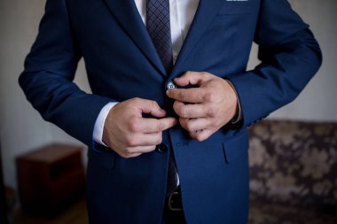 Adam takım elbise giyiyor.