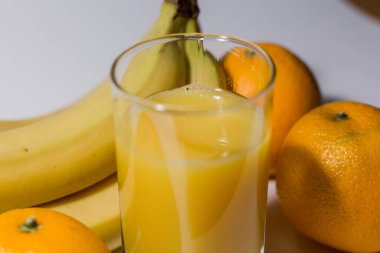 Bir bardakta muz ve portakal suyu