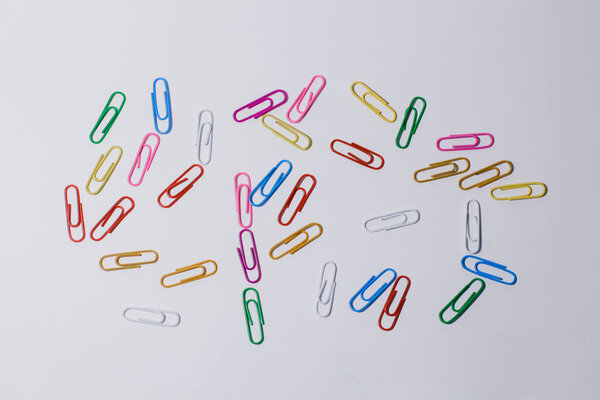 multi-colored paper clips on a white background