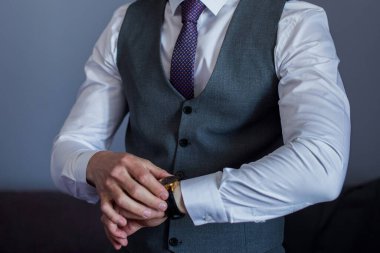 Adam takım elbise giyer.