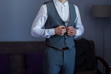 Adam takım elbise giyer.