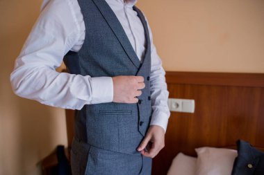 Adam takım elbise giyer.