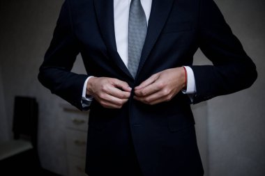 Adam siyah bir takım giyer.