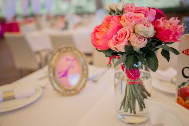 Bir restoranda bir masanın üstünde düğün dekoru.