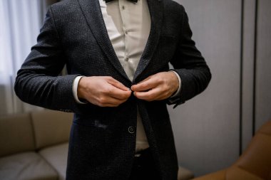 Adam siyah bir takım giyer.