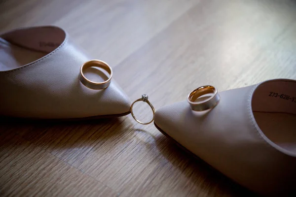 wedding rings with shoes on the table