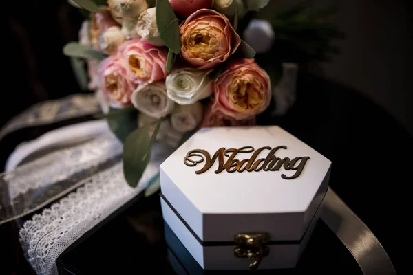 wedding rings with a box near a bouquet