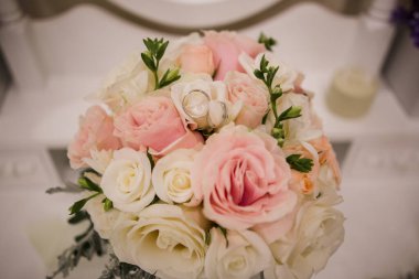 Nikah yüzükleri gelinin buketinin yanında.