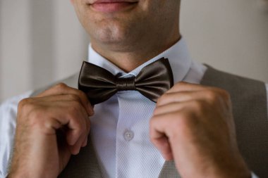 Damat papyonu elleriyle tutuyor.