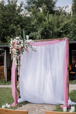 Çiçeklerle süslenmiş bir parkta düğün için kemer.