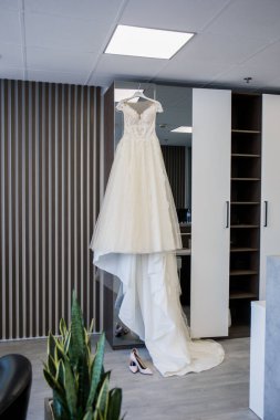 Gelin gelinliği dolapta asılı.