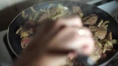 Kadın tavada et kızartıyor.