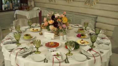 Düğün için çiçeklerle süslenmiş bir restoranda ziyafet masası.