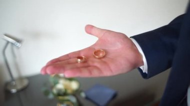 Adam eline alyansları alır.