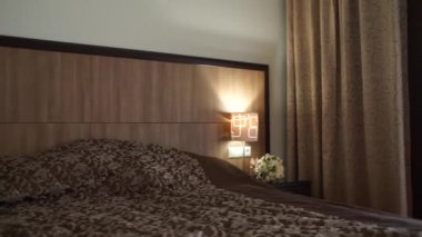 Düğün buketi yatağın yanındaki masada.