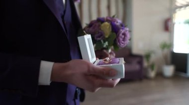 Damat yüzüklü bir kutu tutuyor.