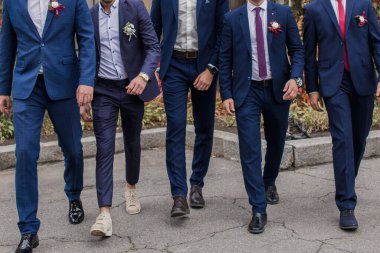 Takım elbiseli adamlar sokakta yürür.