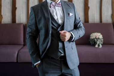 Damat takım elbise giyer.