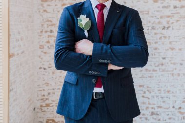 Takım elbiseli damat odada bekliyor.