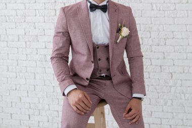 Adam odada takım elbise giyer.