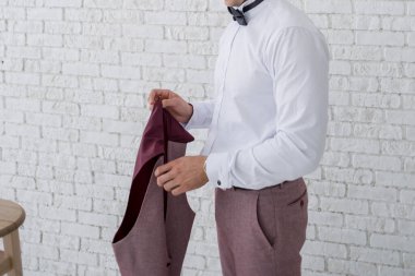 Adam odada takım elbise giyer.