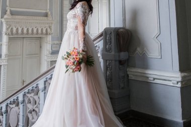 Merdivenlerde buketi olan gelin.