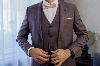 Adam takım elbise giyer.