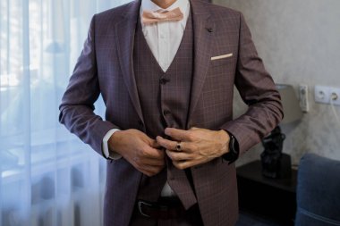 Adam takım elbise giyer.