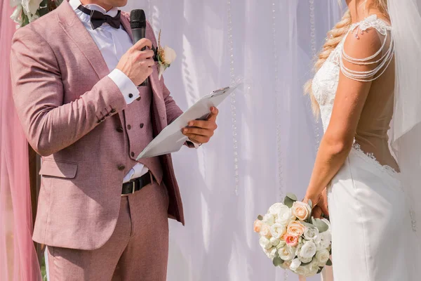 Damat törende mikrofona konuşur.
